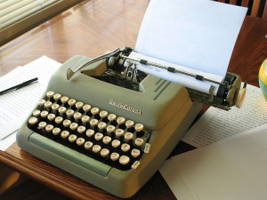 A writer's workstation with a typewriter and notebook